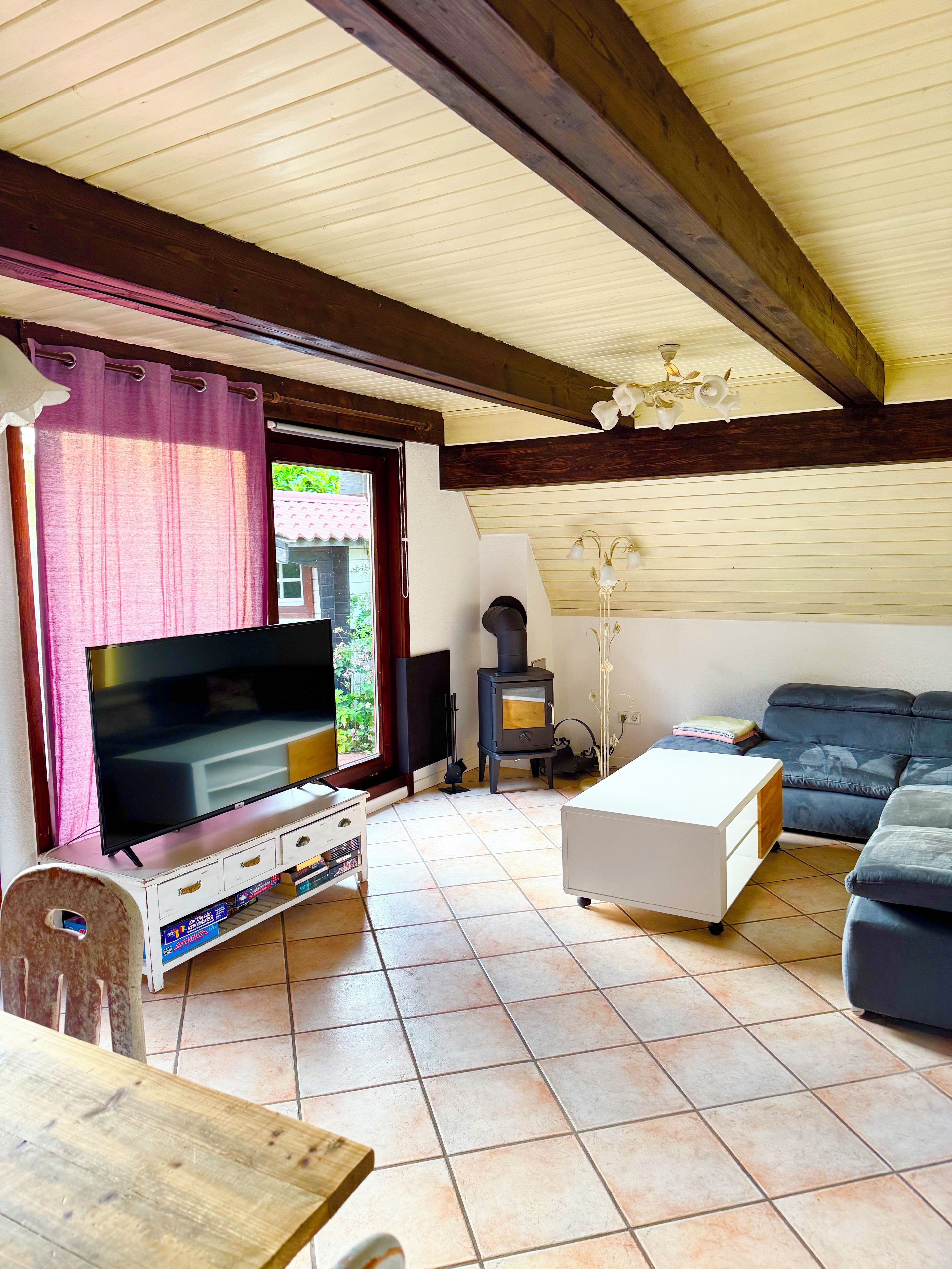 A living room with a television, sofa, and a fireplace.