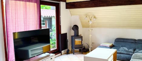 A living room with a television, sofa, and a fireplace.