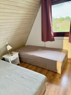 A bedroom with a single bed, a bedside table with a lamp, and a window with curtains. - A small house with a sauna, nestled in the apple orchard of the Altes Land region near Hamburg (Hollern-Twielenfleth)
