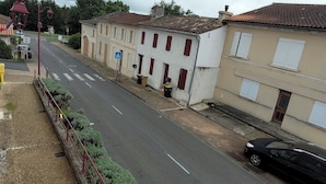 Vista de la calle con edificios, un paso de peatones y un coche estacionado.