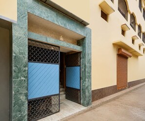 A building entrance with a blue door and a decorative statue above it. - Deluxe Room Shree Ram Residency (Cuttack)