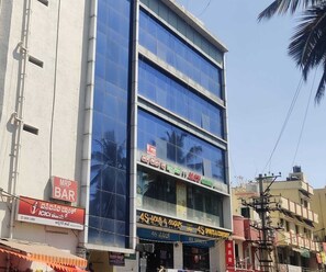 A multi-story building with commercial establishments on the ground floor, including a bank and a bar. - Deluxe Room RTO Office Krishnarajapura (Bengaluru)