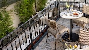 A terrace with a round table, chairs, and a railing. - The Douglas Hotel Savannah (Savannah)