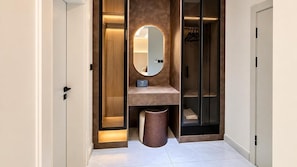 A modern bathroom with a vanity, a mirror, and a walk-in closet. - The Barli Hotel and Apartments (Abuja)