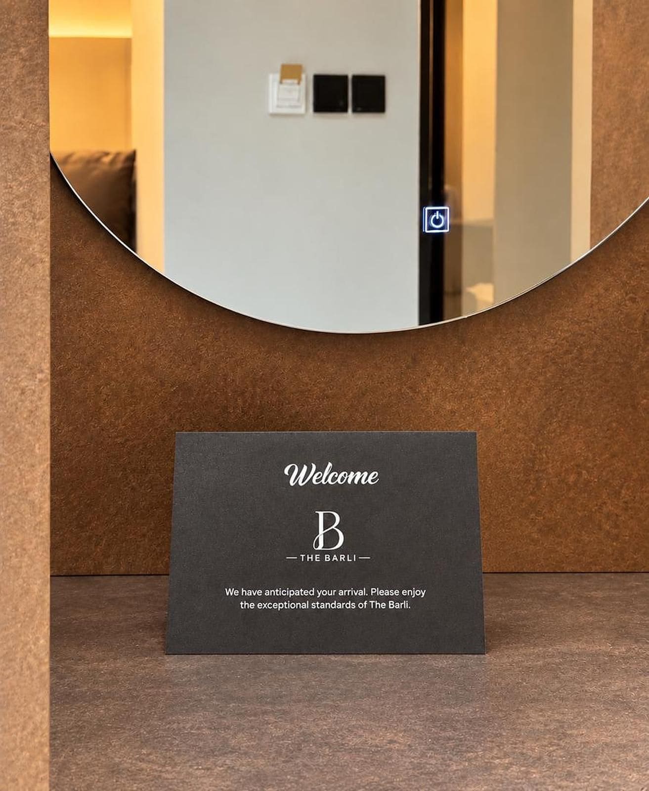 Zona de recepción con un cartel de bienvenida para el hotel 'The Barli'.