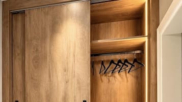 Un armario de madera con puerta corredera, una barra para colgar ropa y un estante para zapatos.
