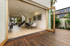 Un espace de vie à aire ouverte comprenant une table à manger, des chaises et un escalier menant à un niveau supérieur.