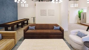 Una sala moderna con un sofá marrón, un sofá blanco, una mesa de centro de madera y un banco.