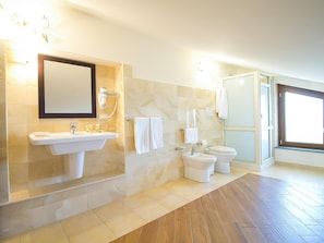 Un baño moderno con lavamanos, espejo, toallero, inodoro y ducha.