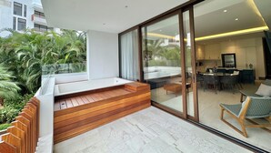 A modern interior with a kitchen, dining area, and a balcony with wooden steps and a seating area. - Vrbo Property (Nuevo Nayarit)