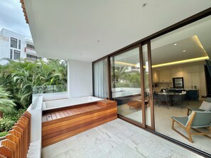 Ein modernes Interieur mit Küche, Essbereich und einem Balkon mit Holzstufen und Sitzgelegenheit.