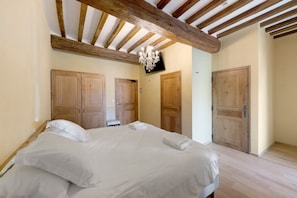 Ein Schlafzimmer mit einem Bett, einem Holzschrank und einem Fernseher.