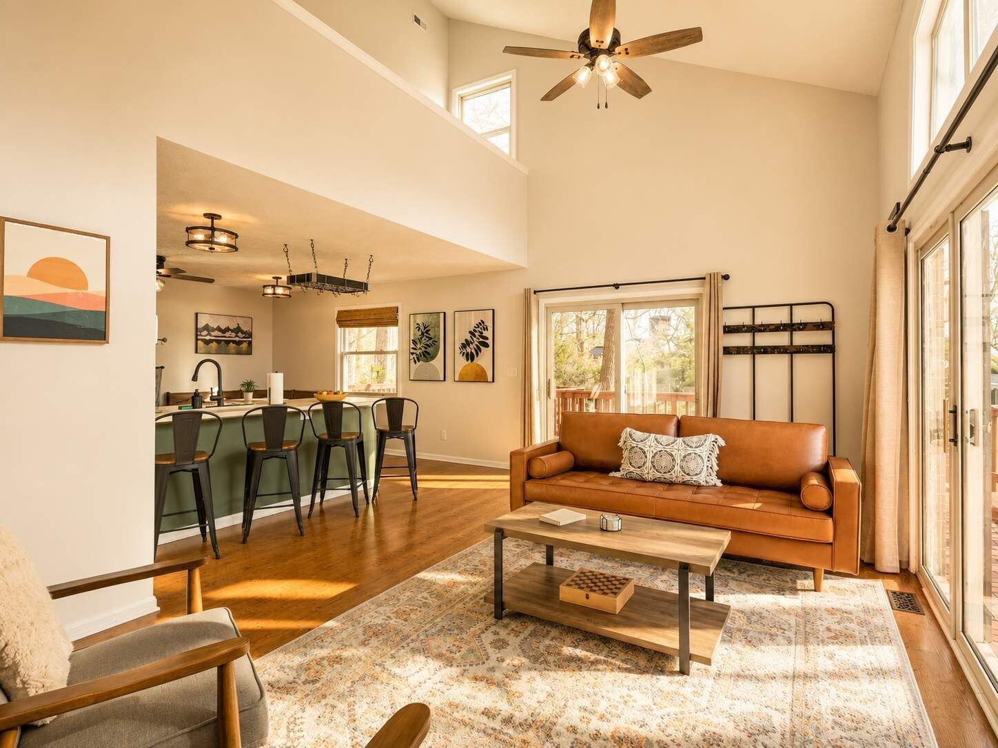 A spacious living room with a brown leather sofa, a coffee table, and a dining area with a bar.