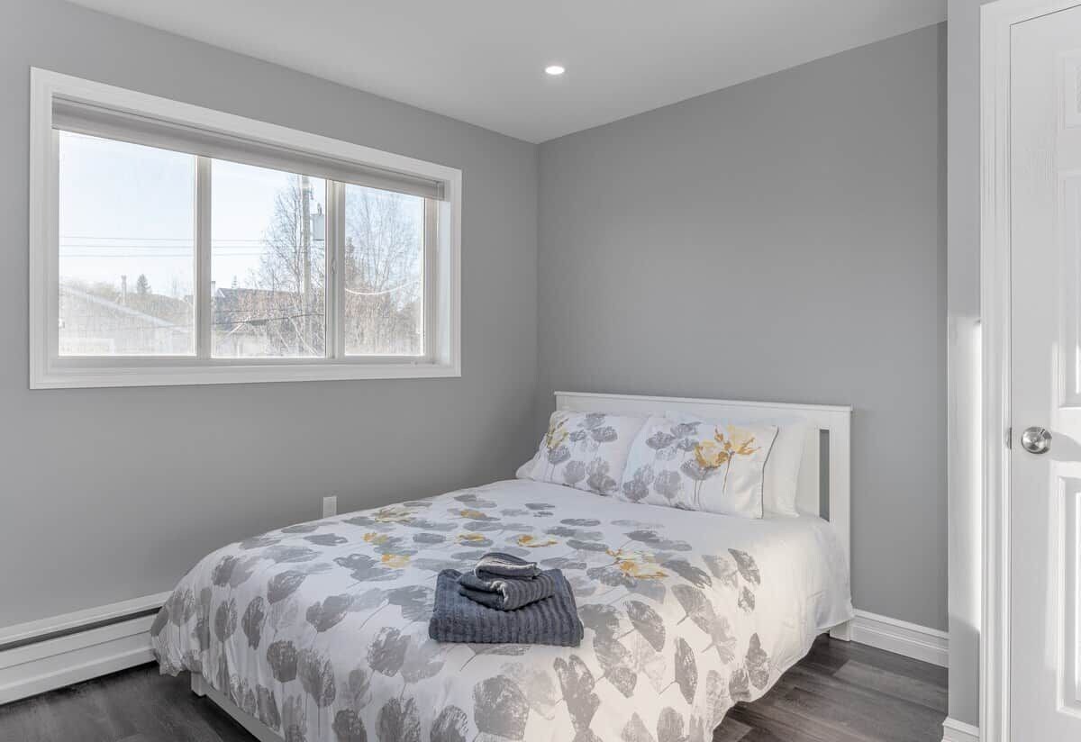 Une chambre à coucher avec un lit, une fenêtre et une porte.