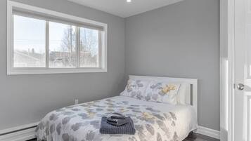 Une chambre à coucher avec un lit, une fenêtre et une porte.