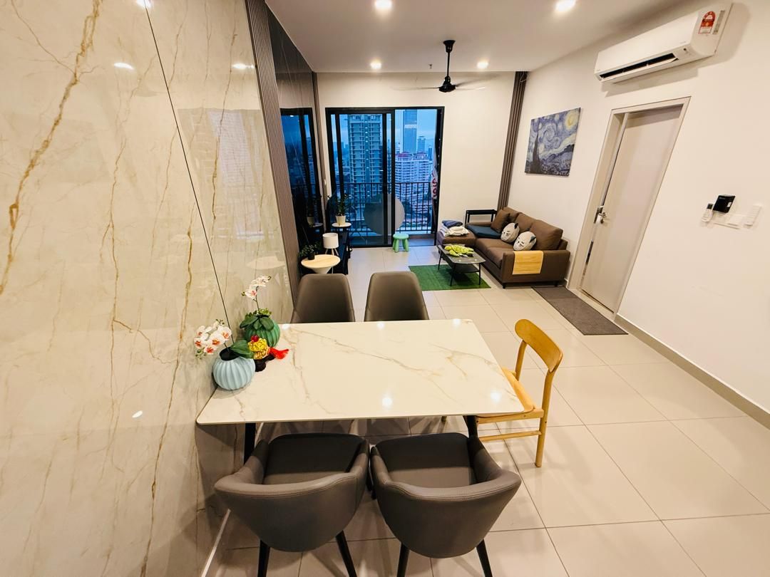 A modern living room with a dining area, a sofa, and a view of a cityscape through large windows.