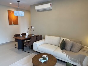 A modern living room with a sofa, dining table, and a coffee table. - SWNK Houze LaLaport BBCC by HomeHorizon (Kuala Lumpur)