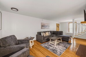 A modern living room with a grey sofa, a coffee table, and a rug.