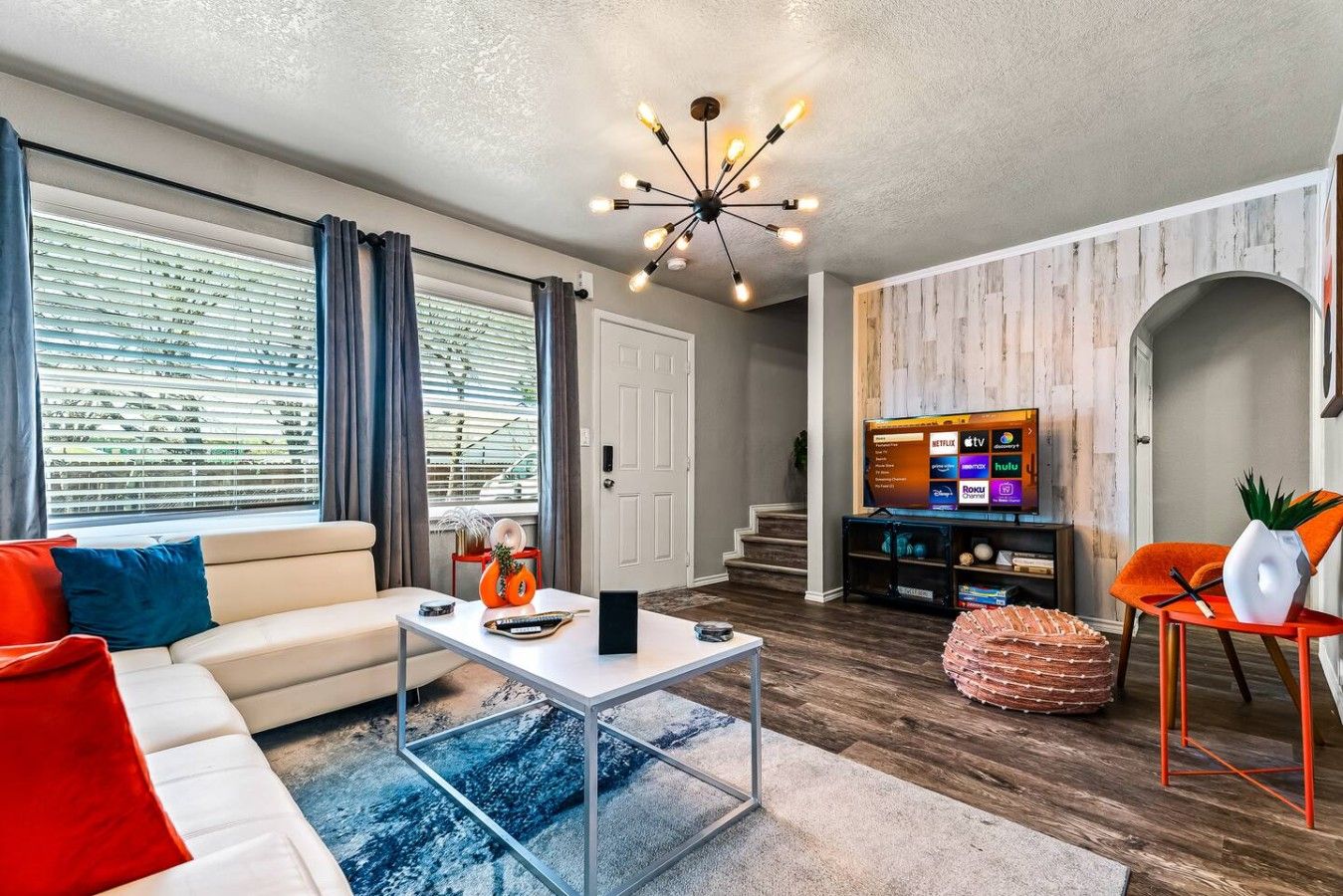 A modern living room with a sofa, coffee table, and a TV.