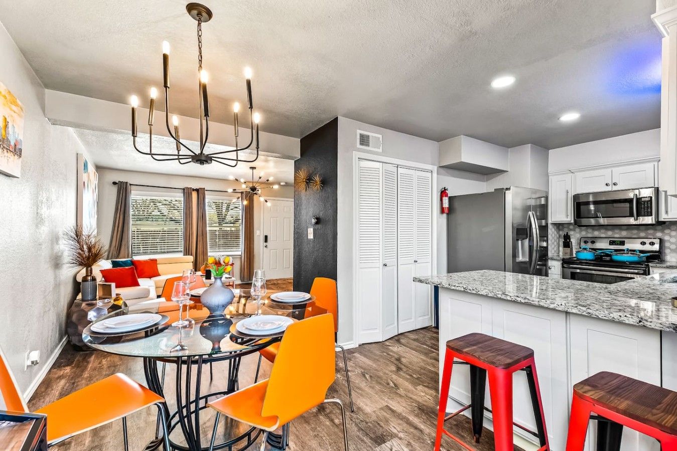 A modern kitchen with a central island, white cabinetry, and stainless steel appliances.