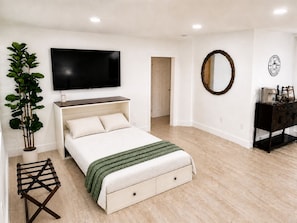 A bedroom with a bed, a television, a mirror, a plant, and a dresser. - Cozy 1-bedroom house in enchanting Miami with AC (Miami)