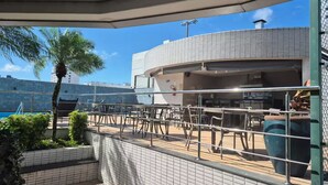 A terrace with outdoor seating, a palm tree, and a building with a tiled facade. - 1204 Unique · Loft Studio Unique with garage 1204 (Sacramenta)