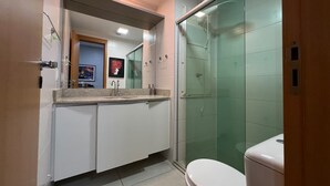 A modern bathroom with a glass shower enclosure, a white toilet, and a countertop with a sink and vanity. - 1204 Unique · Loft Studio Unique with garage 1204 (Sacramenta)