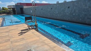 A swimming pool with a ladder and a lifeguard chair, surrounded by a tiled deck. - 1204 Unique · Loft Studio Unique with garage 1204 (Sacramenta)
