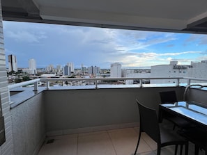 Un balcon avec vue sur la ville, une table et des chaises.