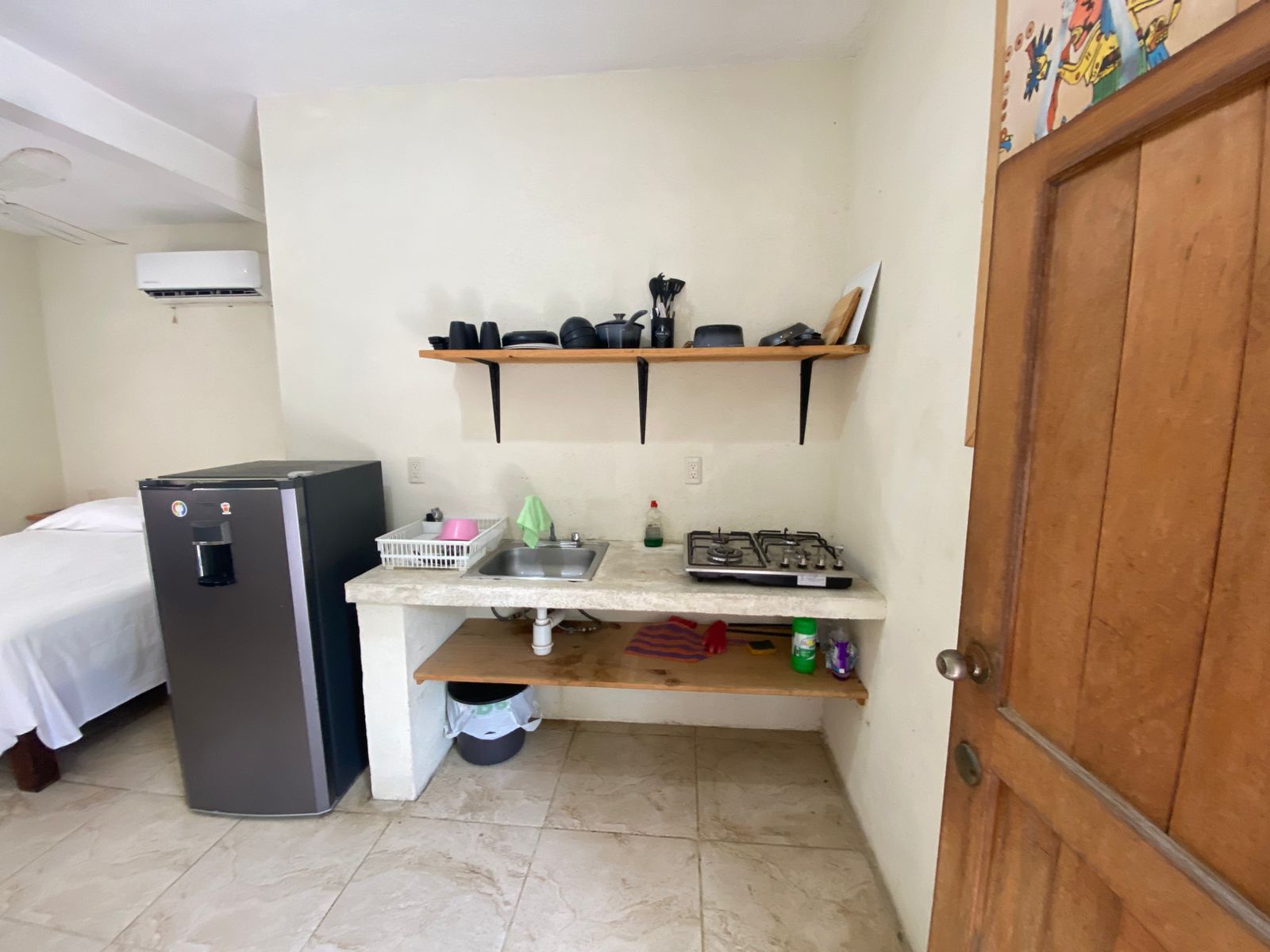 Une petite cuisine équipée d’un réfrigérateur, d’un évier et d’une cuisinière à gaz.