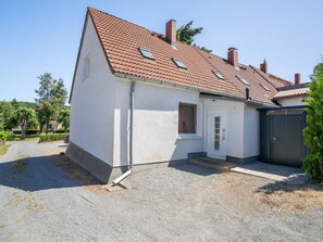 A single-story house with a red-tiled roof, a front door, and a small porch area. - Missi Holiday Apartment (Heringsdorf)