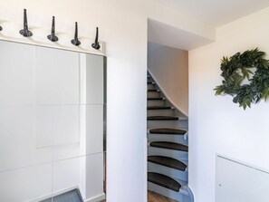 Un escalier moderne avec un mur blanc et une guirlande décorative.
