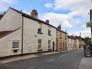 A row of traditional buildings with stone facades, a clear sky, and a signboard for the Yorkshire Hussar Inn. - Bowdery (Harrogate)