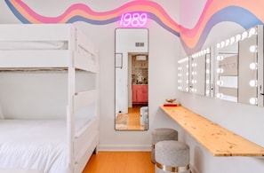 A room with bunk beds, a vanity with mirrors and lights, and a neon sign. - Glam Society Music Row-IG Worthy-Outdoor Lounge (Nashville)