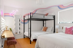 A bunk bed room with a mirror, a desk, a chair, and a bedside table with a lamp. - Legends Lounge Glam Suite On Music Row IG Worthy (Nashville)