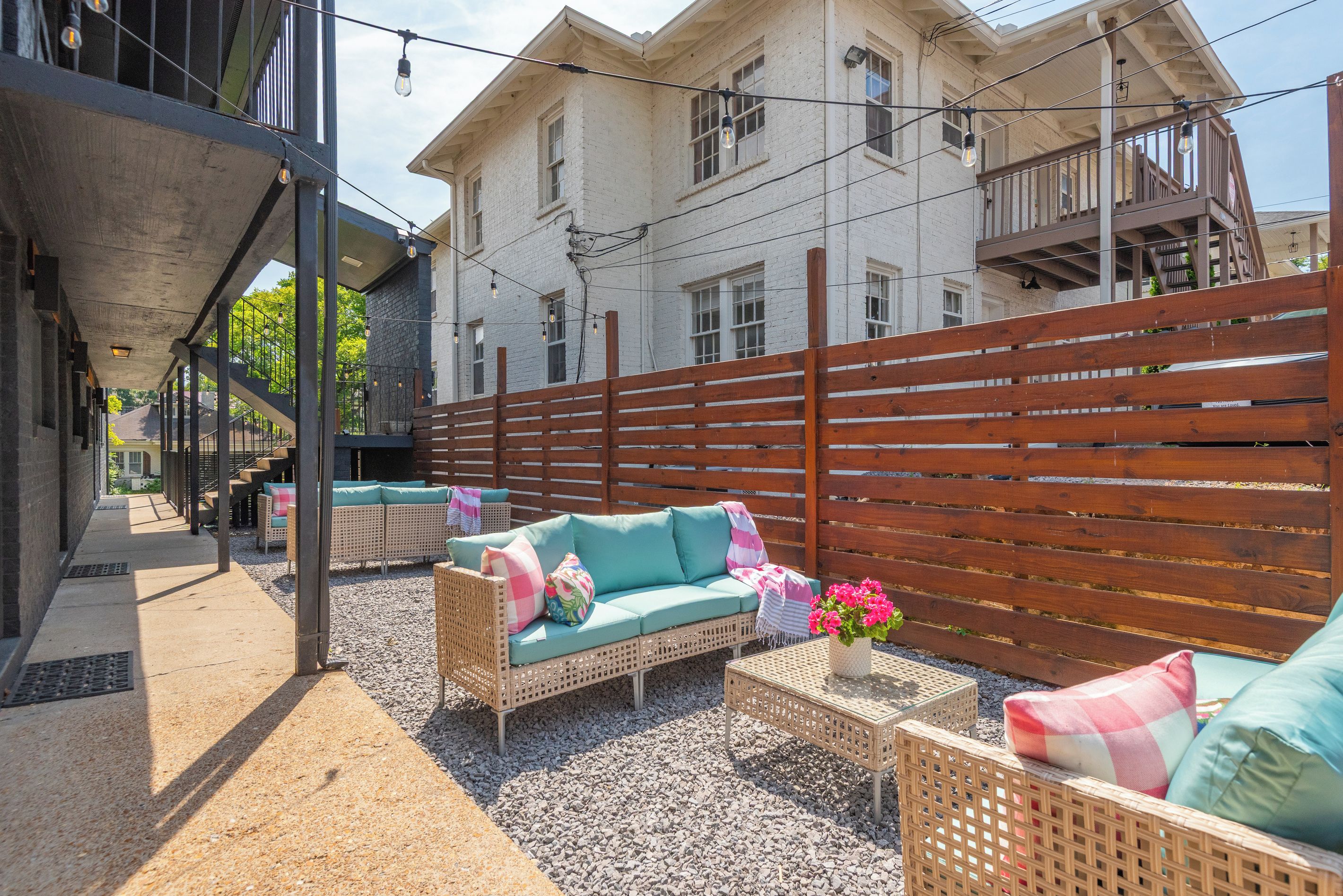 An outdoor seating area with wicker furniture and a wooden fence.
