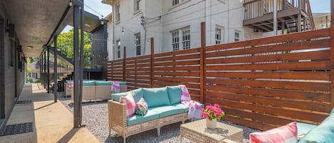 Un espace extérieur aménagé avec des meubles en osier et une clôture en bois.