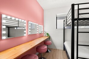 A room with a vanity area featuring a mirror with lights, a wooden shelf, and a bunk bed with a window. - The Muse Girls Glam Suite Near Broadway IG Worthy (Nashville)
