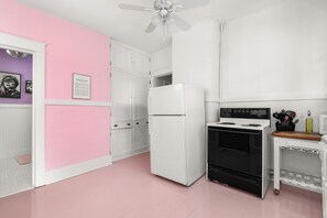 A kitchen with a white refrigerator, black oven, and a ceiling fan. - Taylor's Music Row Glam Near Broadway IG Worthy (Nashville)