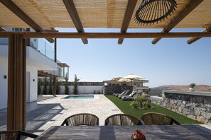 Eine moderne Außenpatio mit Pool, Liegestühlen und einer Steinwand.