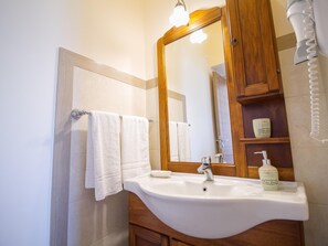 A bathroom with a sink, mirror, towel rack, and toiletries. - Panoramic Sea-view Apartment (Trecastagni)