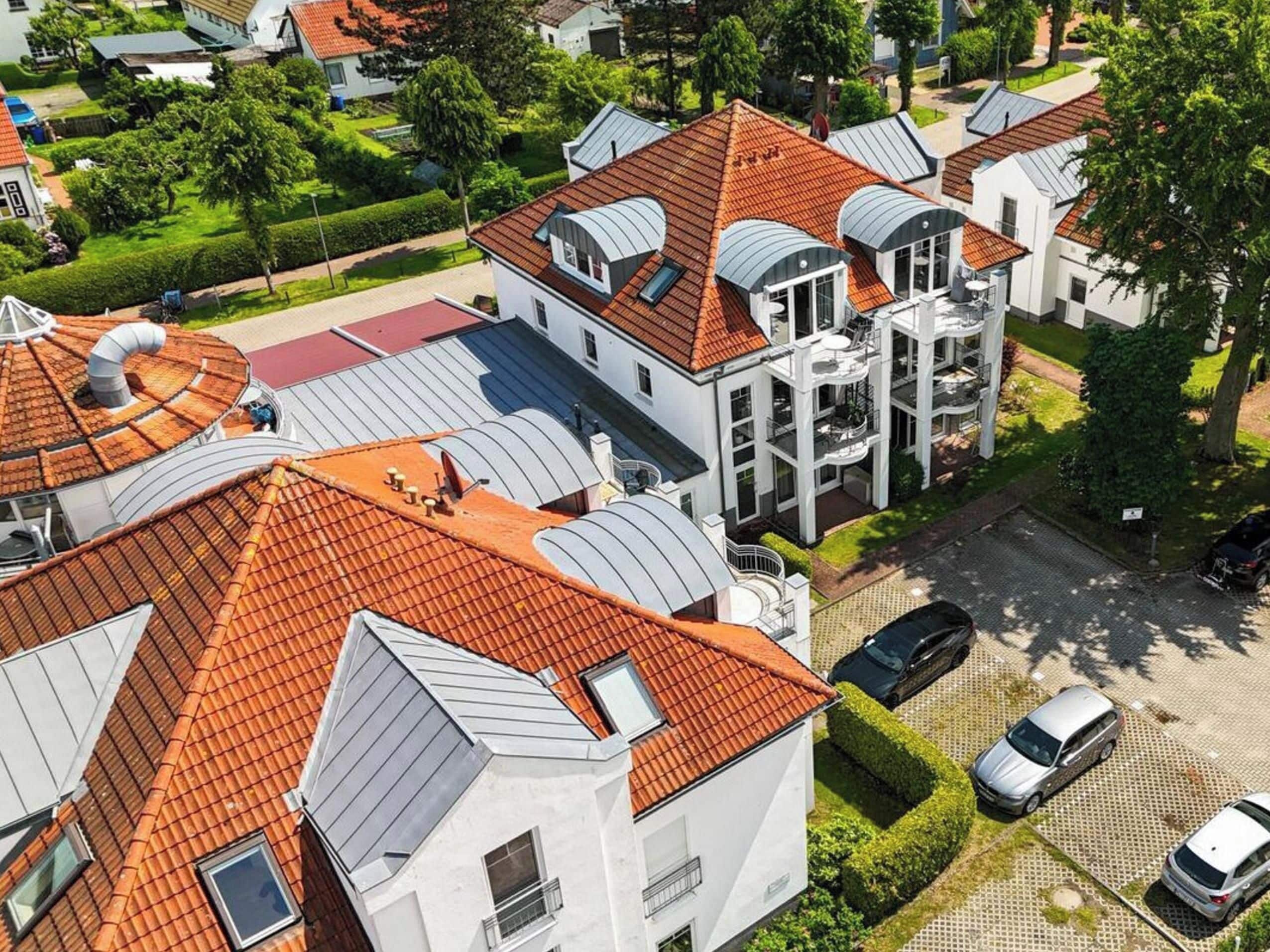 A residential area with modern houses featuring red-tiled roofs and large windows.