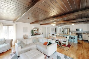 A spacious living room with a large white sectional sofa, a dining area with a table and chairs, and a kitchen with modern appliances. - Bear Den - Near Yosemite & Bass Lake, Deck (Oakhurst)