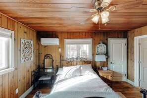 A bedroom with a bed, a ceiling fan, a window, a door, and a wall-mounted clock. - Bear Den - Near Yosemite & Bass Lake, Deck (Oakhurst)