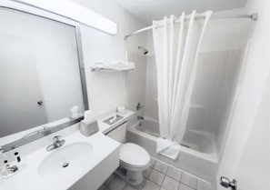 A bathroom with a sink, toilet, and bathtub.