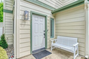 A house with a white door, a bench outside, and a small tree in the front yard. - Slide Creek Retreat - Pool, Hot Tub, Walk to Lake (Bass Lake)