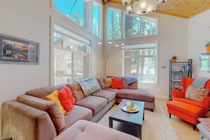 A modern living room with a sectional sofa, a coffee table, and a bookshelf.