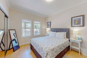 A bedroom with a large bed, two bedside tables, a mirror, and a window. - Granite Tranquility - Private Sauna & Fireplace (Yosemite West)