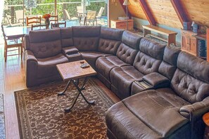 A modern living room with a sectional sofa, a small table, and a patterned rug. - Alford Family Lodge - Walk to Bass Lake, 2 Decks (Bass Lake)
