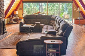Una sala acogedora con un sofá modular, una mesita y una chimenea.